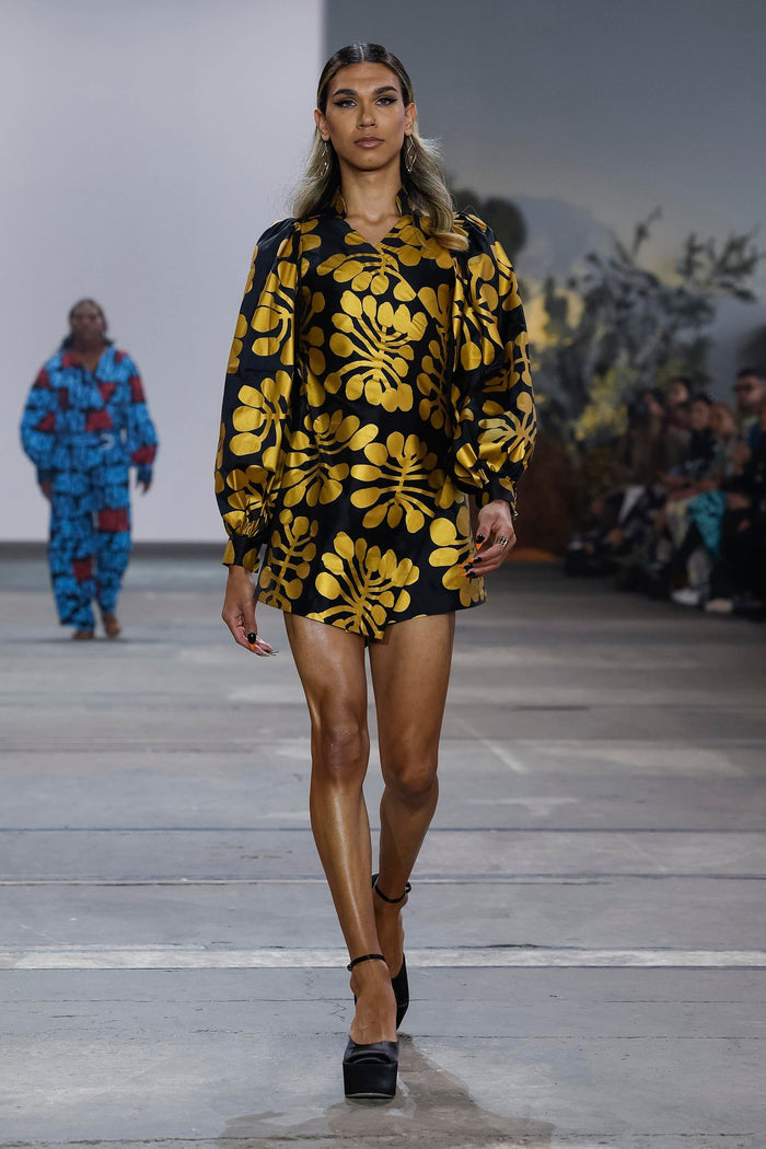 Wrap around gold on black mini dress in Mitjili Napurrula’s Watiya Tjuta silk OSSOM x Ikuntji Artists AAFW '23